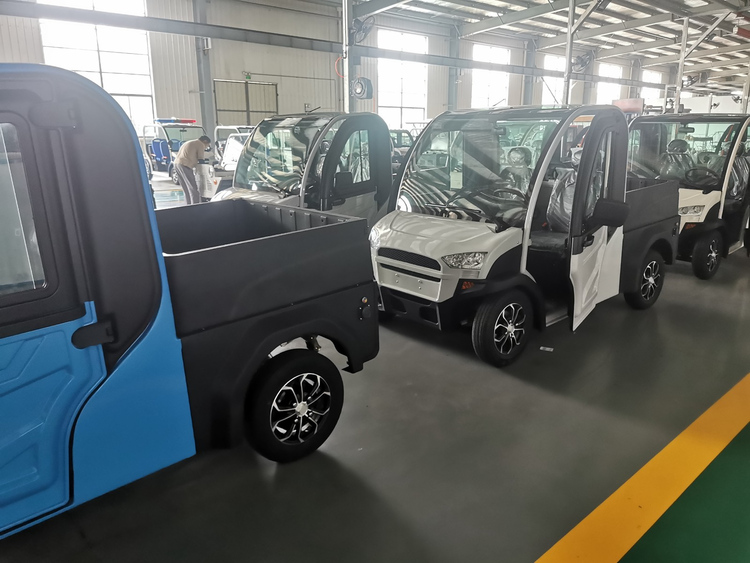 Blue and white electric cargo vans checked before shipment