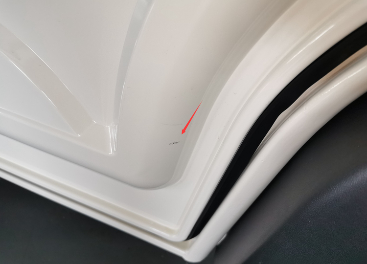 Minor paint finish imperfection on a white electric van