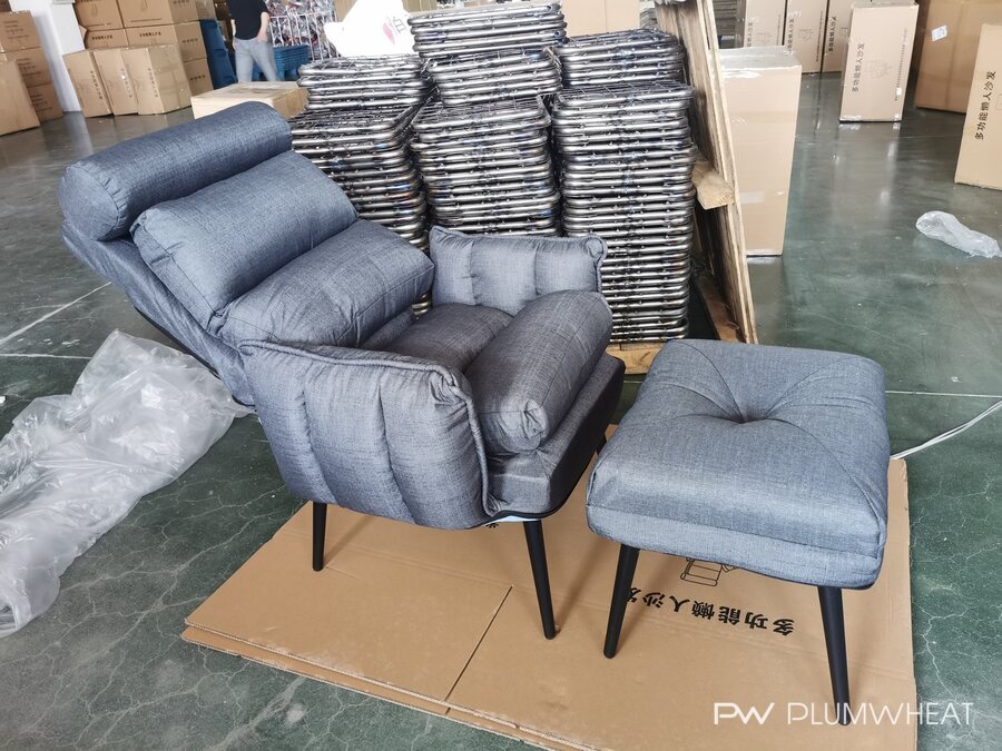 Grey upholstered leisure chair in an adjusted position with a matching footstool.