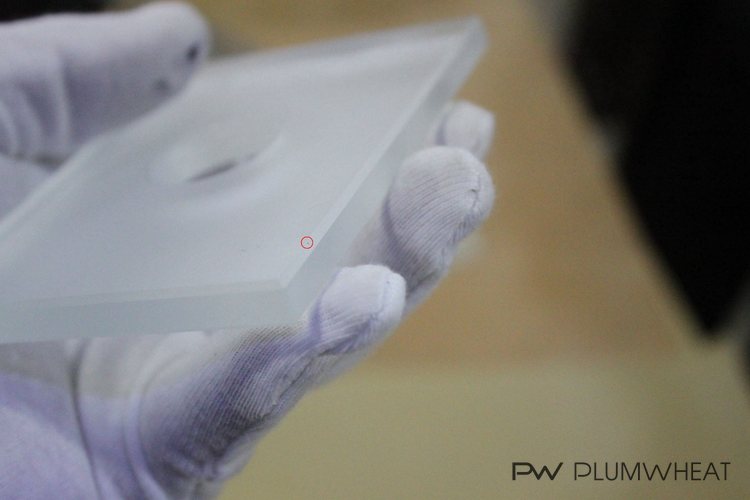 Close-up of a tiny black dot found on an LED glass component during inspection