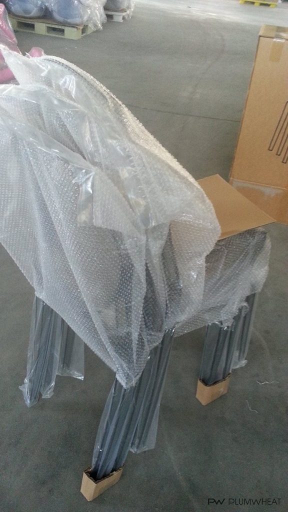 Four assembled PW884 leisure chairs stacked with protective material for export packing