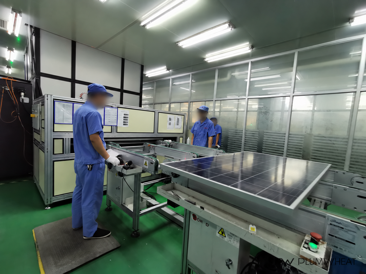 Workers operating a solar module inspection station in a Chinese factory