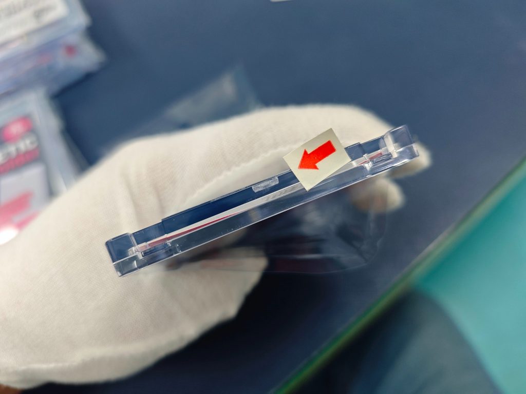 Close-up inspection photo showing a minor scratch on a transparent magnetic holder.